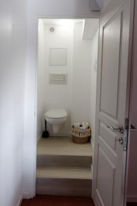 baño con aseo y puerta blanca en La Douce Cathare, en Carcassonne