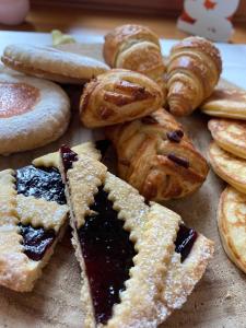 un montón de diferentes tipos de pasteles en una mesa en Residenza d'Epoca Albergo Grimani, en Ampezzo