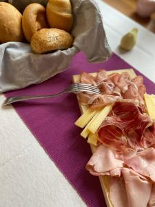 eine Platte mit Fleischkäse und Brot in der Unterkunft Residenza d'Epoca Albergo Grimani in Ampezzo