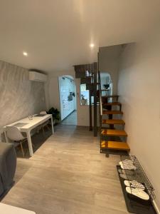 a living room with a staircase and a table at Maisonnette avec terrasse in Strasbourg