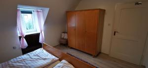 Un dormitorio con una cama y un armario y una ventana. en Ferienwohnung Palmenwald, en Freudenstadt