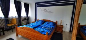 1 dormitorio con cama de madera con sábanas azules en Ferienwohnung Palmenwald, en Freudenstadt 11 fotos más