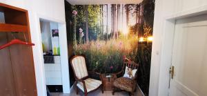a hallway with two chairs and a painting on the wall at Ferienwohnung Palmenwald in Freudenstadt
