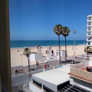 a view of a beach with palm trees and the ocean at Apartamento reformado con vistas al mar in Cádiz