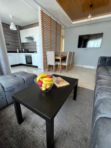 a living room with a table with a bowl of fruit on it at Appartement El jadida Sidi Bouzid in Sidi Bouzid