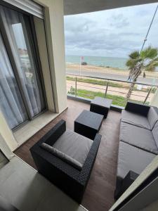 uma sala de estar com um sofá e vista para a praia em Appartement El jadida Sidi Bouzid em Sidi Bouzid