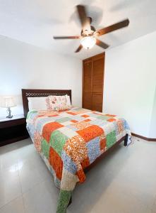 1 dormitorio con 1 cama y ventilador de techo en Costa Linda walking distance to the beach, en Jacó