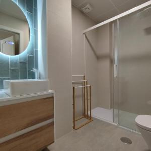 a bathroom with a shower and a sink and a mirror at Apartamento reformado con vistas al mar in Cádiz