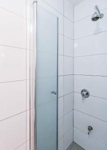 La salle de bains est pourvue d'une douche avec une porte en verre. dans l'établissement Downtown by the beach apartment, à Tel Aviv
