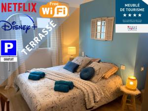 een slaapkamer met een bed met blauwe kussens erop bij Latitude Savoie in Drumettaz-Clarafond