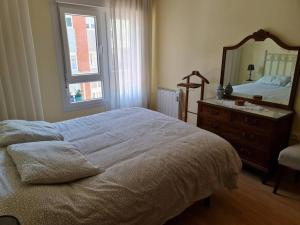 a bedroom with a bed and a mirror and a dresser at Casa Roge in Luarca