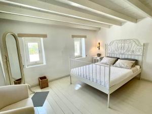 1 dormitorio con 1 cama blanca y 1 silla en Villa Santa Maria-Sophia en Kampos Paros