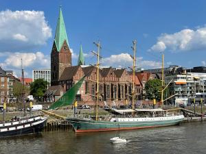 dois barcos estão ancorados na água perto de uma cidade em Exklusive Ferienwohnung 5km vom Centrum em Bremen