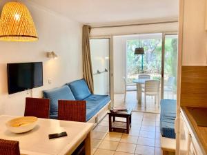 een woonkamer met een blauwe bank en een tafel bij Les Restanques glycines 2066 in Grimaud