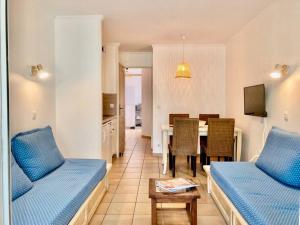 een woonkamer met 2 bedden en een eetkamer bij Les Restanques glycines 2066 in Grimaud