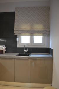 uma cozinha com um lavatório e uma janela em Kalamaria brand new 2 bedroom apartment em Tessalônica