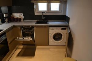 uma cozinha com um lavatório e uma máquina de lavar roupa em Kalamaria brand new 2 bedroom apartment em Tessalônica
