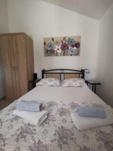 a bedroom with a bed with two towels on it at Holiday home Penić in Rogoznica
