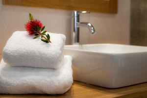 a pile of towels on a counter next to a sink at Nissos Apartments in Myrina
