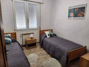 1 dormitorio con 2 camas y 2 ventanas en Fausto&Deby Apartment en Oriago