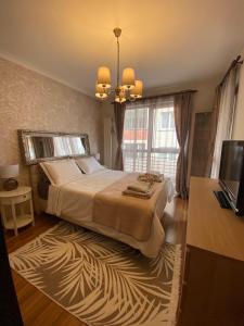 a bedroom with a large bed and a television at Home From Home in Sofia