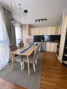 kuchnia i jadalnia z drewnianym stołem i krzesłami w obiekcie Home From Home w mieście Sofia