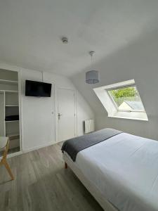 - une chambre blanche avec un lit et une fenêtre dans l'établissement Hôtel Restaurant Le Mur du Roy, à Sarzeau