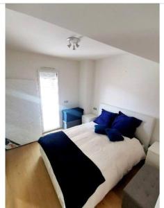 1 dormitorio con 1 cama grande con almohadas azules en Monaco Monte-Carlo door step - Luxury Apartment - 2 Bedrooms 2 Bathrooms - Superb Modern Fully Equipped en Saint-Antoine