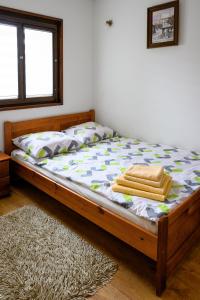 a bed with a wooden frame with towels on it at Domek na zacisznych obrzeżach Kazimierza Dolnego in Kazimierz Dolny