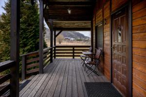 a porch of a wooden cabin with a table and a chair at Domek na zacisznych obrzeżach Kazimierza Dolnego in Kazimierz Dolny