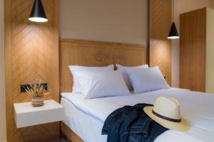 a bedroom with a bed with a hat on it at Nissos Apartments in Myrina
