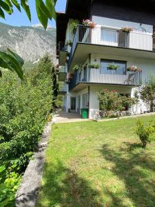 a building with flowers on the balconies and a yard at Pension Alpina in Roppen