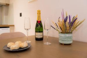 a bottle of wine and two glasses on a table at Nissos Apartments in Myrina