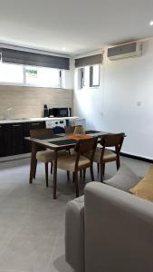 a living room with a table and a kitchen at Nuben Court- Kumasi City in Kumasi