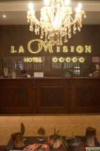 a restaurant with a chandelier and a bar at Hotel La Mision in San Ignacio de Velasco