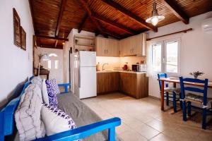a kitchen with a table and a white refrigerator at Floreica Maisonneta By the Sea. in Skinária