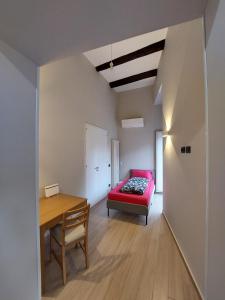 Habitación con cama roja y mesa. en Cosy Domy Apartments en Nápoles