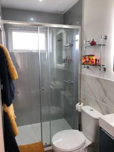 een badkamer met een glazen douche met toilet bij Bosun's Bude in Bude