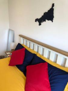 a bed with colorful pillows in a room at Bosun's Bude in Bude