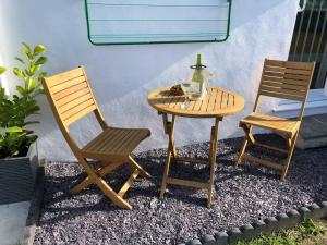 two chairs and a table and a table with a bottle on it at Bosun's Bude in Bude