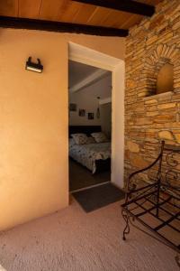 a bedroom with a bed and a stone wall at Villa Comorebi Provence in Entrecasteaux