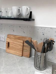 een aanrecht met een messenblok en een emmer met keukengerei bij Bosun's Bude in Bude