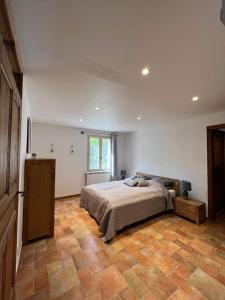 1 dormitorio con 1 cama y suelo de madera en Villa Comorebi Provence, en Entrecasteaux