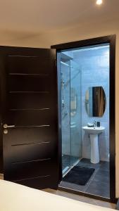 a bathroom with a glass shower and a sink at Nuben Court- Kumasi City in Kumasi