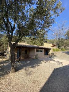 una pequeña casa con un árbol delante en Villa Comorebi Provence, en Entrecasteaux
