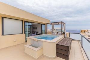 a hot tub on the balcony of a house at Unique penthouse with private pool & sea view in St. Paul's Bay