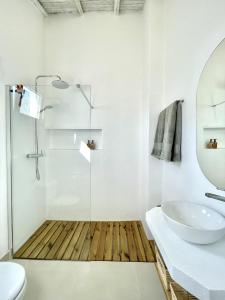 La salle de bains est pourvue d'une douche en verre et d'un lavabo. dans l'établissement Casa XS, à Alvor