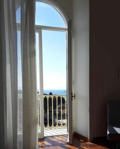 une porte ouverte s'ouvrant sur un balcon avec vue sur l'océan. dans l'établissement Casa Giulia, à Vietri