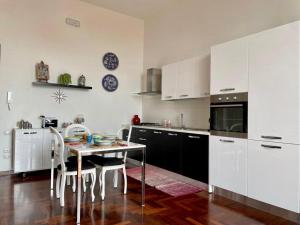 a kitchen with white cabinets and a table and chairs at Casa Giulia in Vietri sul Mare