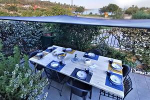 - une table avec des plats bleus sur la terrasse dans l'établissement Villetta Il Faro sul Mare, à Àrbatax